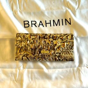This is a cream and light brown with gold streaks, two snaps Brahmin wallet.
